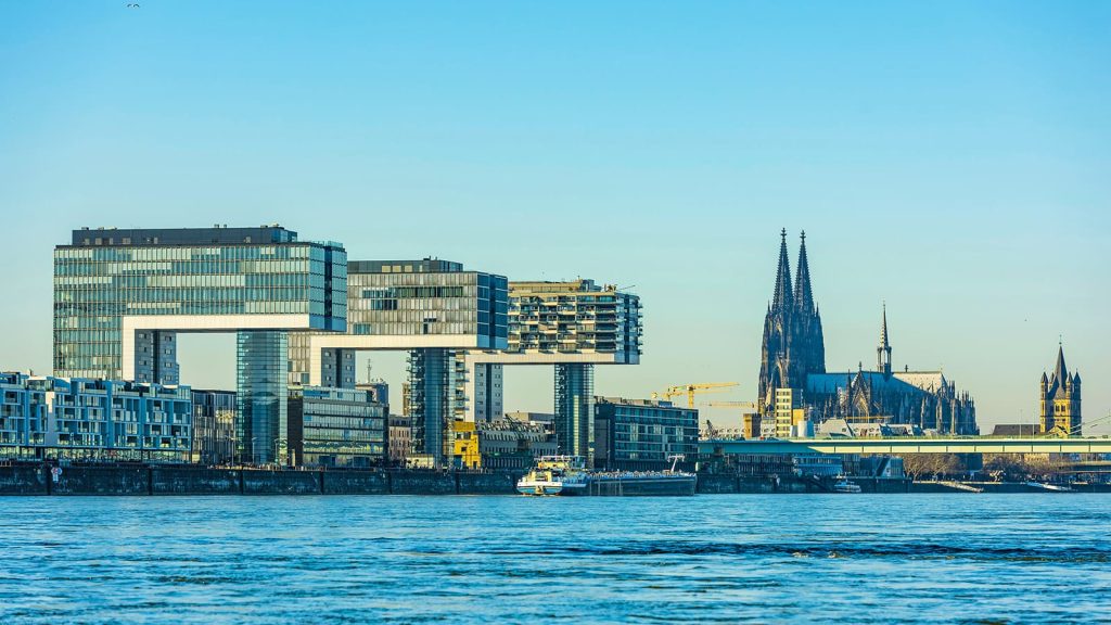 Kranhäuser in Köln vom Wasser aus, im Hintergrund der Kölner Dom.
