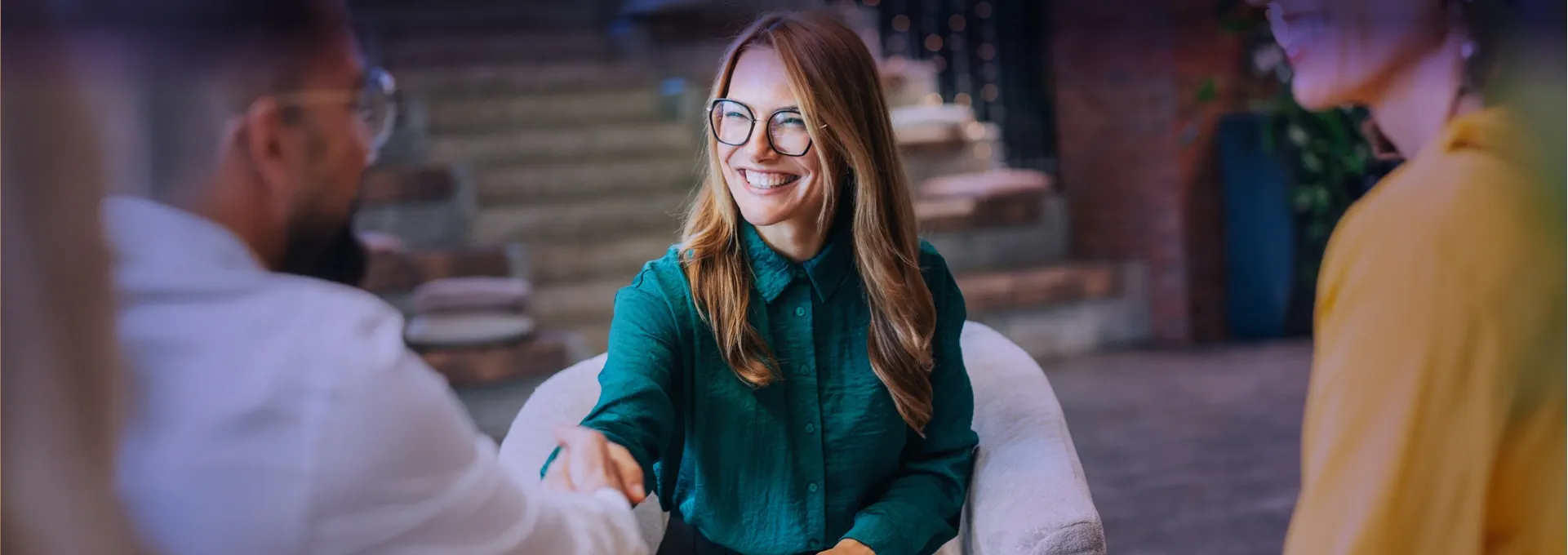 Eine Frau und ein Mann schütteln sich lächelnd die Hände.